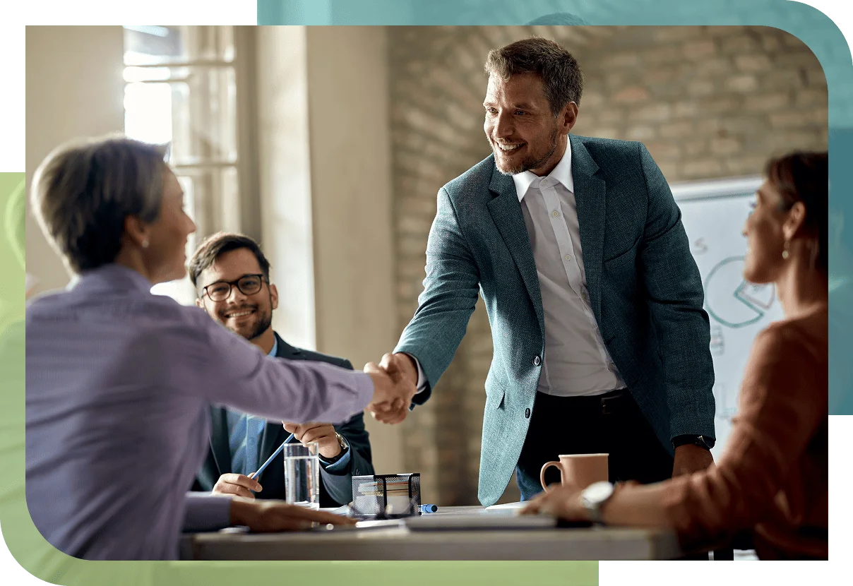 Successful business collaboration shown by a professional shaking hands with a client during a team meeting.